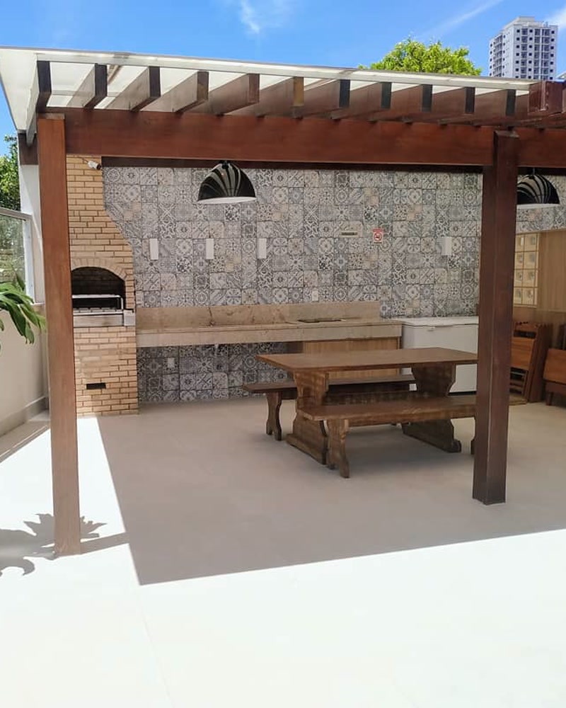 Churrasqueira com pergolado de madeira na área comum de edifício residencial revitalizada pela Simo Engenharia